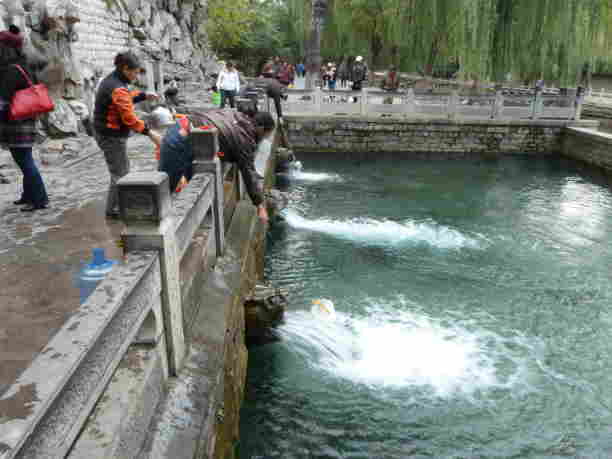 Someone getting water from the springs in Jinan