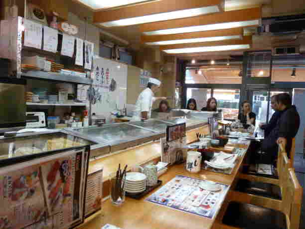 The inside of a sushi restaurant near Tsukiji Fish Market, complete with a grumpy Japanese sushi chef